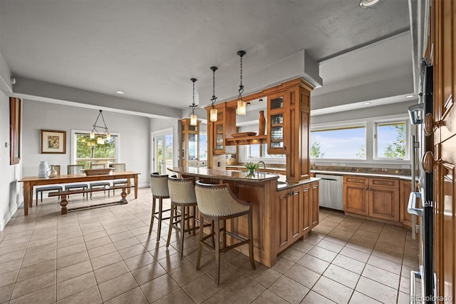 1425 Autumnwood Ln, Evergreen, CO 80439 - kitchen featuring a kitchen breakfast bar, brown cabinets, stainless steel dishwasher, dark countertops, and healthy amount of natural light