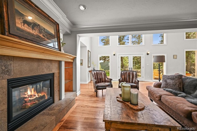 1425 Autumnwood Ln, Evergreen, CO 80439 - living room featuring crown molding, hardwood / wood-style floors, a tiled fireplace, plenty of natural light, and recessed lighting