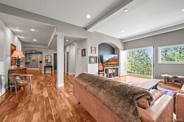1425 Autumnwood Ln, Evergreen, CO 80439 - living room featuring arched walkways, light wood-style floors, baseboards, recessed lighting, and beamed ceiling