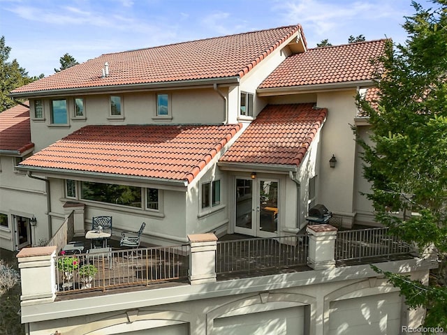 1425 Autumnwood Ln, Evergreen, CO 80439 - back of property with a tiled roof, a balcony, french doors, and stucco siding