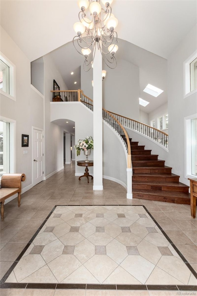 1425 Autumnwood Ln, Evergreen, CO 80439 - foyer with a towering ceiling, stairs, light tile patterned floors, a chandelier, and inlaid floor details