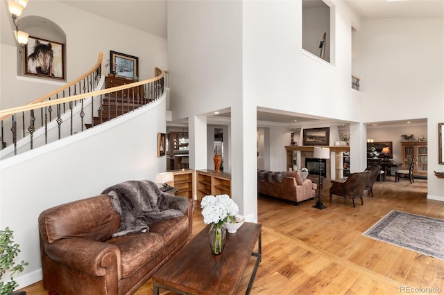 1425 Autumnwood Ln, Evergreen, CO 80439 - living room with a towering ceiling, wood finished floors, stairs, and a glass covered fireplace