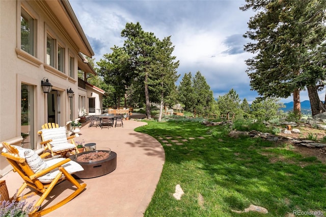1425 Autumnwood Ln, Evergreen, CO 80439 - view of green lawn featuring an outdoor fire pit, a patio area, and outdoor dining space