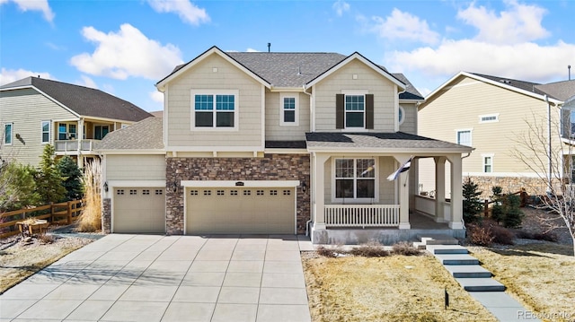 view of front of house featuring fence, a porch, concrete driveway, a garage, and stone siding