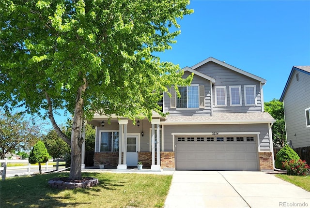 view of front facade with a garage, a front yard, brick siding, and driveway