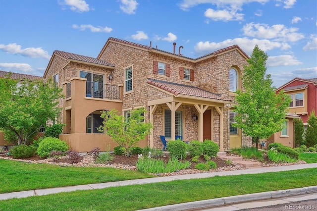 9528 Pendio Ct, Highlands Ranch, CO 80126 - view of front of property with stone siding, a tiled roof, a front yard, a balcony, and stucco siding