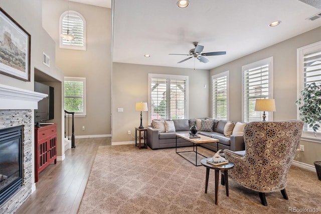 9528 Pendio Ct, Highlands Ranch, CO 80126 - living room with a stone fireplace, light wood finished floors, baseboards, ceiling fan, and recessed lighting