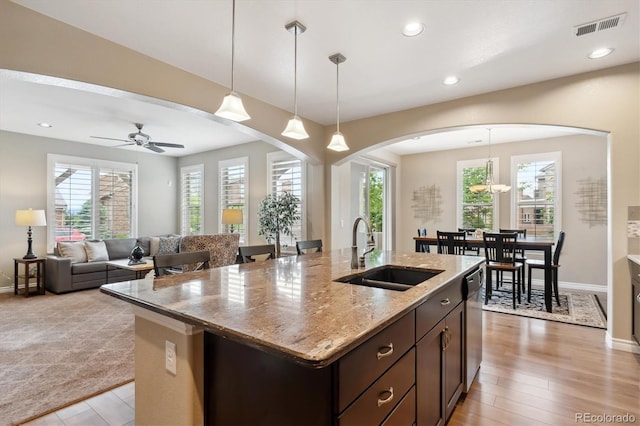 9528 Pendio Ct, Highlands Ranch, CO 80126 - kitchen featuring a sink, arched walkways, healthy amount of natural light, a center island with sink, and recessed lighting