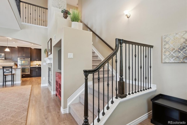 9528 Pendio Ct, Highlands Ranch, CO 80126 - stairway featuring a high ceiling and wood finished floors