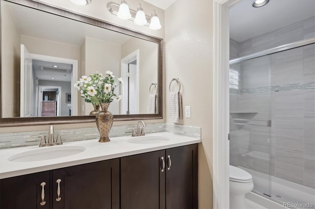9528 Pendio Ct, Highlands Ranch, CO 80126 - bathroom with double vanity, toilet, a shower stall, and backsplash