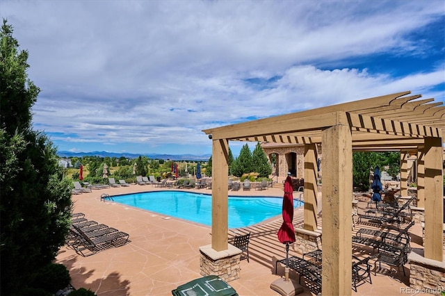 9528 Pendio Ct, Highlands Ranch, CO 80126 - community pool featuring a pergola, a patio area, and a mountain view