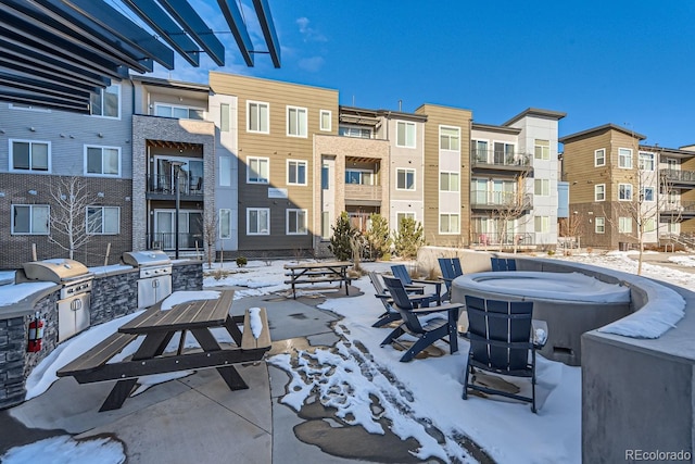 snow covered patio featuring exterior kitchen and area for grilling