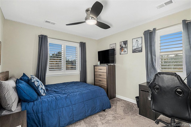 carpeted bedroom featuring ceiling fan and multiple windows