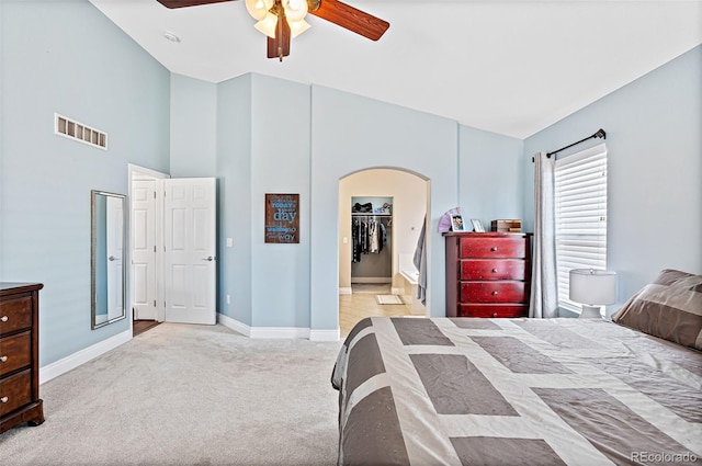 2209 Lupine Pl, Erie, CO 80516 - bedroom featuring arched walkways, carpet flooring, lofted ceiling, a ceiling fan, and a spacious closet