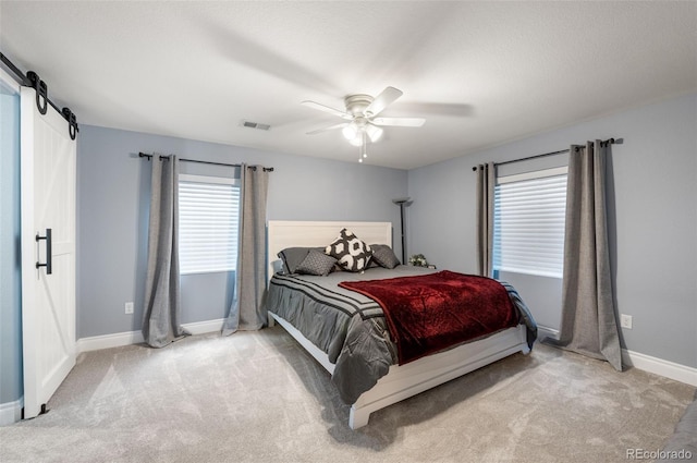 2209 Lupine Pl, Erie, CO 80516 - bedroom with carpet floors, multiple windows, a barn door, and a ceiling fan
