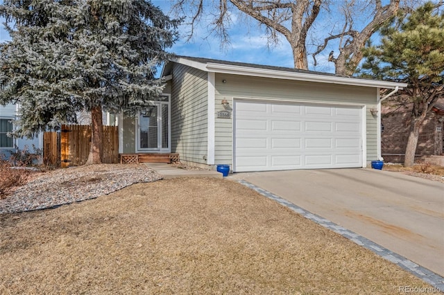 view of property exterior featuring driveway, an attached garage, and fence