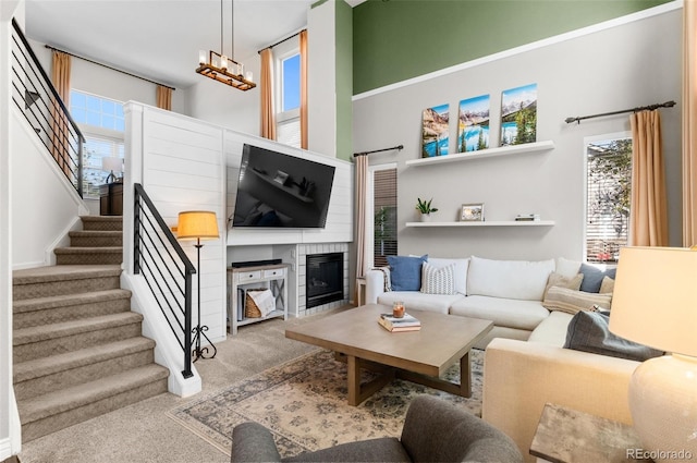 8864 S Field Ct, Littleton, CO 80128 - carpeted living area featuring stairs, a glass covered fireplace, and a high ceiling