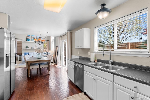 8864 S Field Ct, Littleton, CO 80128 - kitchen with appliances with stainless steel finishes, a sink, a chandelier, dark countertops, and white cabinetry
