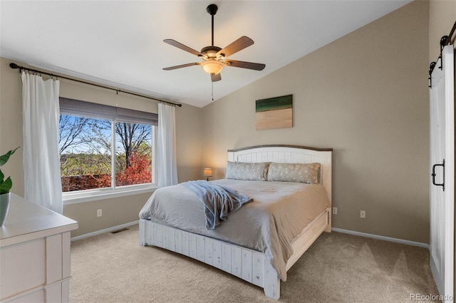 8864 S Field Ct, Littleton, CO 80128 - bedroom with a barn door, vaulted ceiling, baseboards, light colored carpet, and ceiling fan