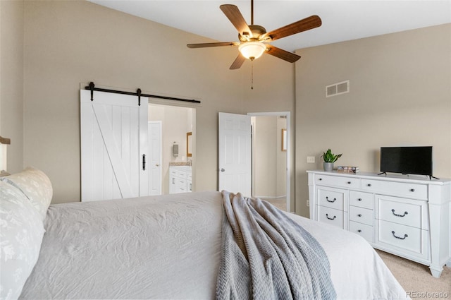 8864 S Field Ct, Littleton, CO 80128 - bedroom with high vaulted ceiling, light colored carpet, a barn door, ceiling fan, and ensuite bath
