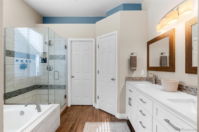 8864 S Field Ct, Littleton, CO 80128 - full bathroom with a stall shower, double vanity, wood finished floors, and a bath