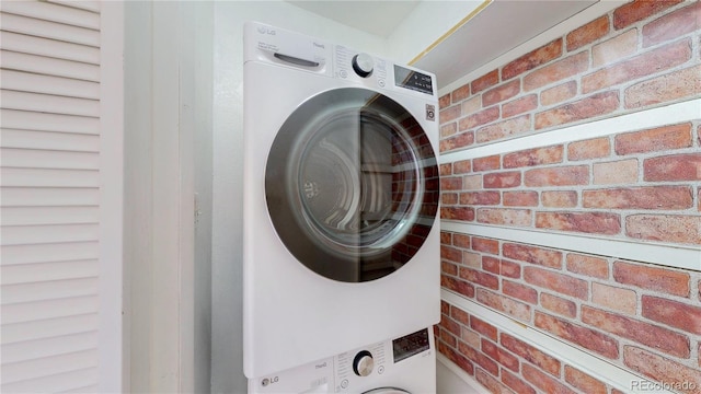 12120 Melody Dr Unit 308, Westminster, CO 80234 - clothes washing area with estacked washer and dryer and brick wall