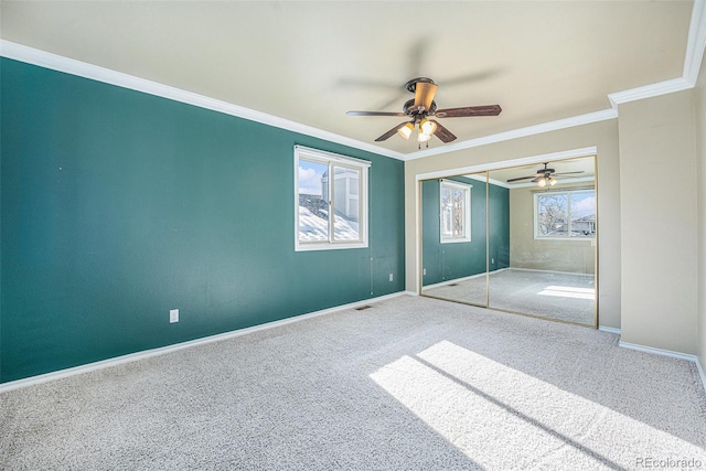 unfurnished bedroom featuring carpet flooring, a closet, ornamental molding, and ceiling fan