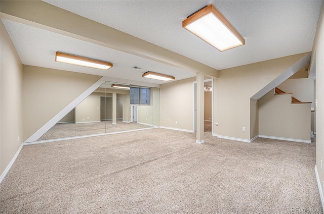 basement featuring a textured ceiling and carpet floors