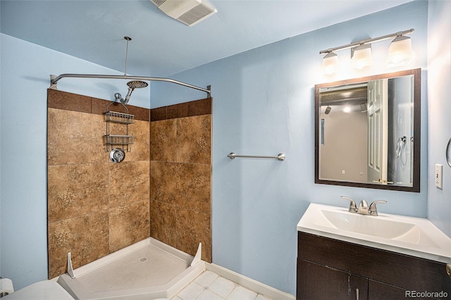 bathroom with a tile shower, tile patterned floors, and vanity