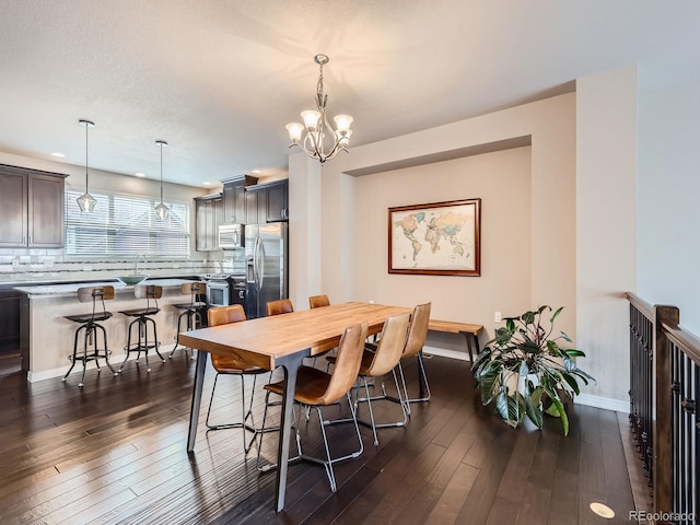 dining area with a chandelier, dark hardwood / wood-style flooring, and sink