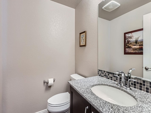 bathroom featuring backsplash, vanity, and toilet