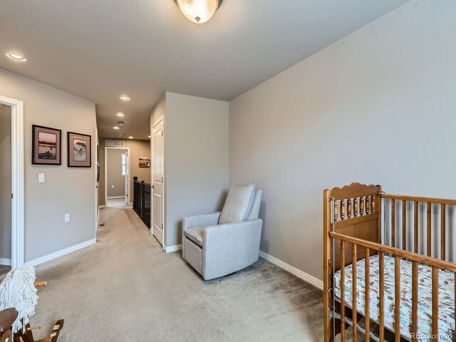 bedroom featuring a crib and light carpet