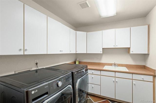 laundry room with cabinets, washer and clothes dryer, and sink