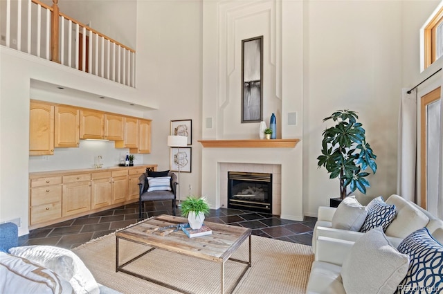 living room featuring a fireplace, a high ceiling, and sink