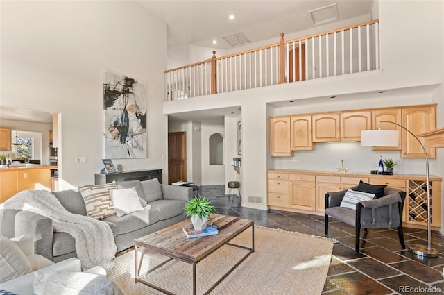 living room featuring a towering ceiling and sink