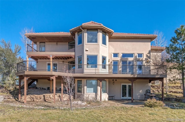 rear view of house featuring a lawn and a patio