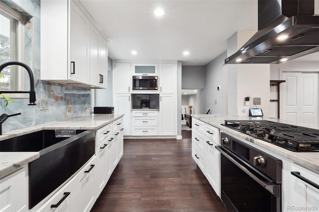 kitchen with light stone countertops, wall chimney exhaust hood, decorative backsplash, dark wood-style floors, and black appliances