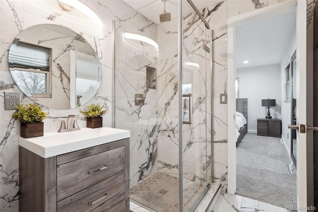 ensuite bathroom featuring ensuite bathroom, stone wall, vanity, marble finish floor, and a marble finish shower