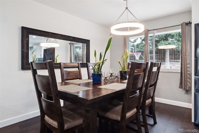 dining space featuring baseboards and dark wood finished floors