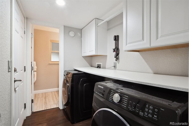 laundry area featuring cabinet space, baseboards, dark wood finished floors, and independent washer and dryer