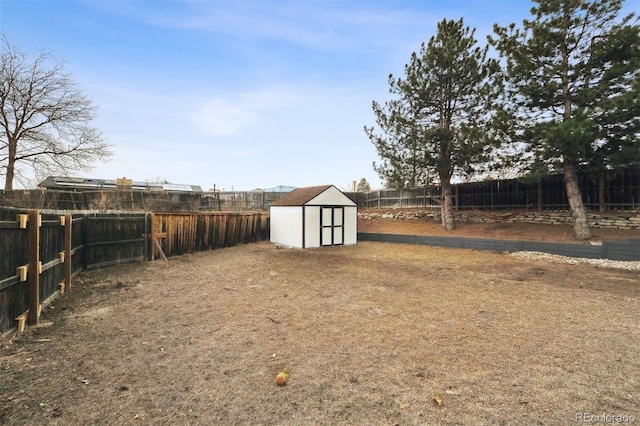 view of yard with an outbuilding, a shed, and a fenced backyard