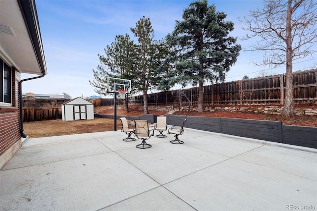 view of patio featuring an outbuilding, a fenced backyard, and a shed