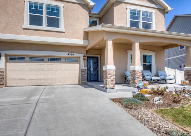 4330 Prairie Agate Dr, Colorado Springs, CO 80938 - view of front facade featuring a porch, stucco siding, stone siding, and an attached garage