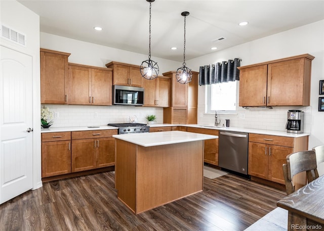 4330 Prairie Agate Dr, Colorado Springs, CO 80938 - kitchen featuring stainless steel appliances, brown cabinets, dark wood-style flooring, and recessed lighting
