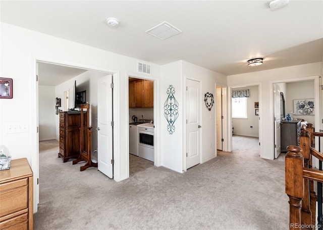 4330 Prairie Agate Dr, Colorado Springs, CO 80938 - hall featuring light colored carpet, an upstairs landing, and independent washer and dryer