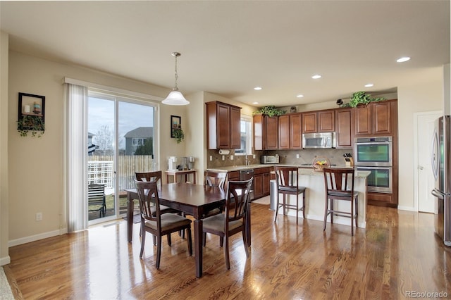2033 E 167th Way, Thornton, CO 80602 - dining room with healthy amount of natural light, wood finished floors, baseboards, and recessed lighting