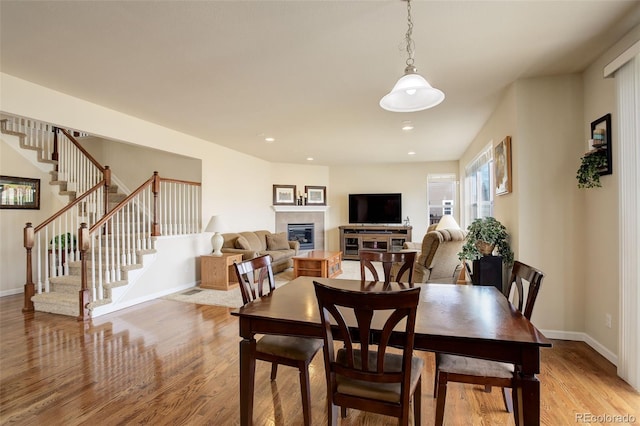 2033 E 167th Way, Thornton, CO 80602 - dining area with light wood finished floors, a tiled fireplace, stairs, baseboards, and recessed lighting