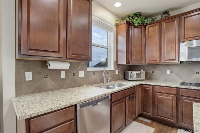 2033 E 167th Way, Thornton, CO 80602 - kitchen featuring appliances with stainless steel finishes, a sink, backsplash, and light stone counters