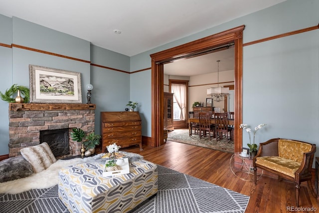 131 N Sherman St, Denver, CO 80203 - living area with wood finished floors, a chandelier, and a stone fireplace