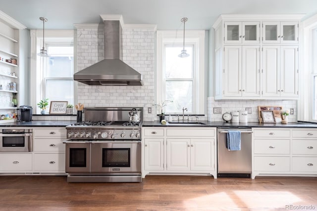 131 N Sherman St, Denver, CO 80203 - kitchen with appliances with stainless steel finishes, wall chimney exhaust hood, a sink, dark countertops, and tasteful backsplash